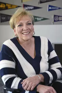 Dr. Angie Paccione smiling in a black and white striped sweater